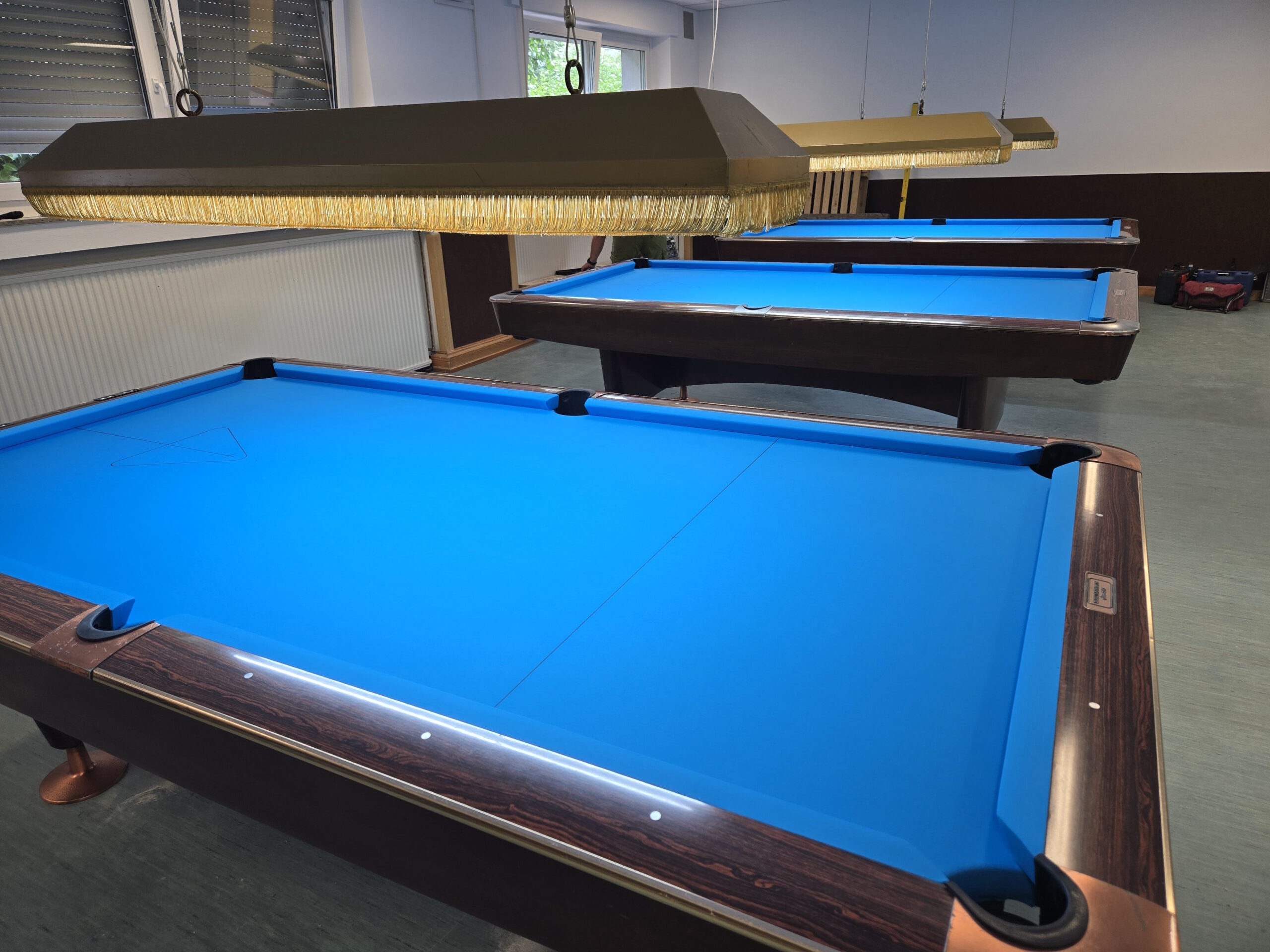Blick über blaue Poolbillardtische im Vereinsheim